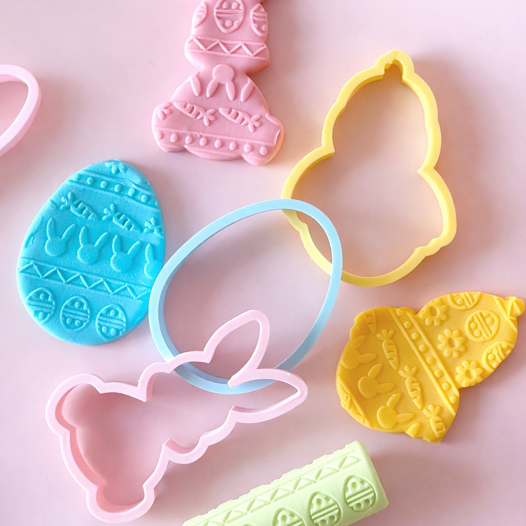 Set of colorful cookie cutters on a pink background