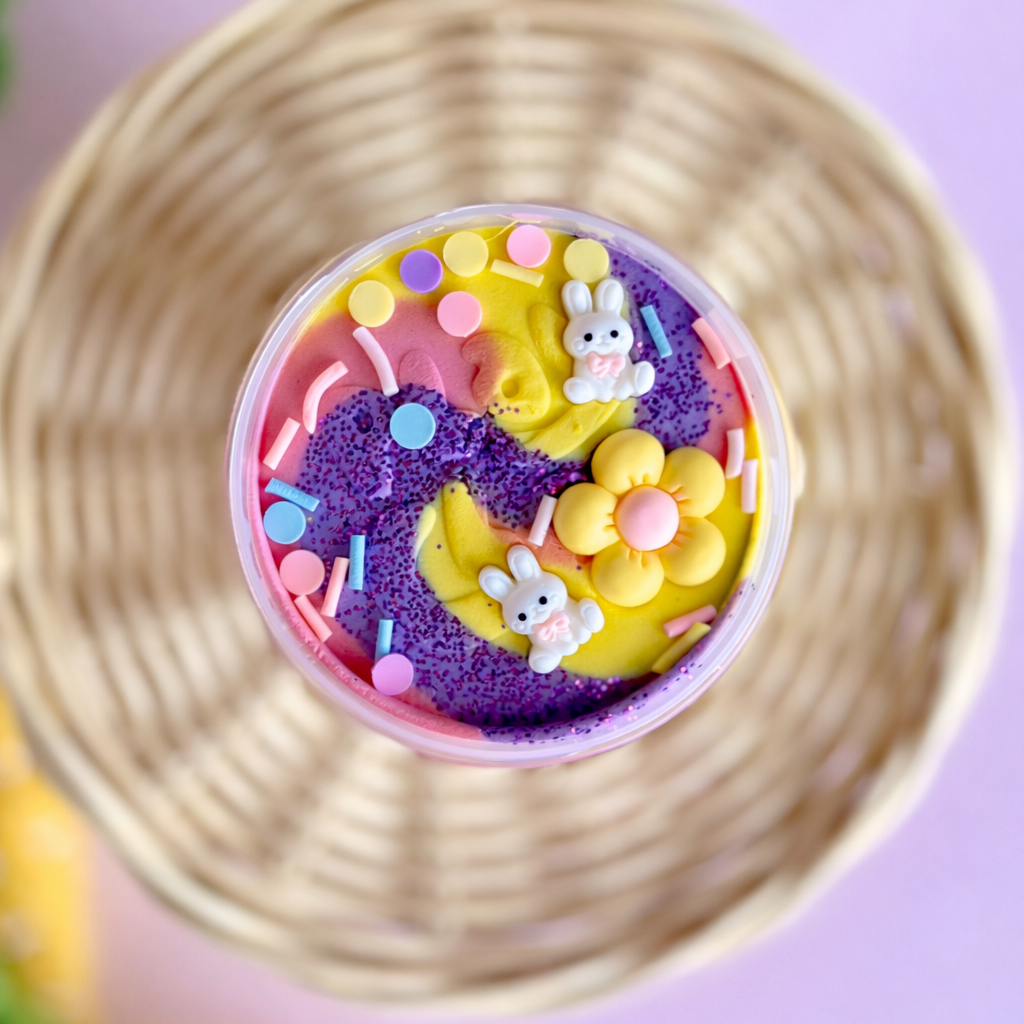 Colorful toy with rabbit figures in a wicker basket on a pink background